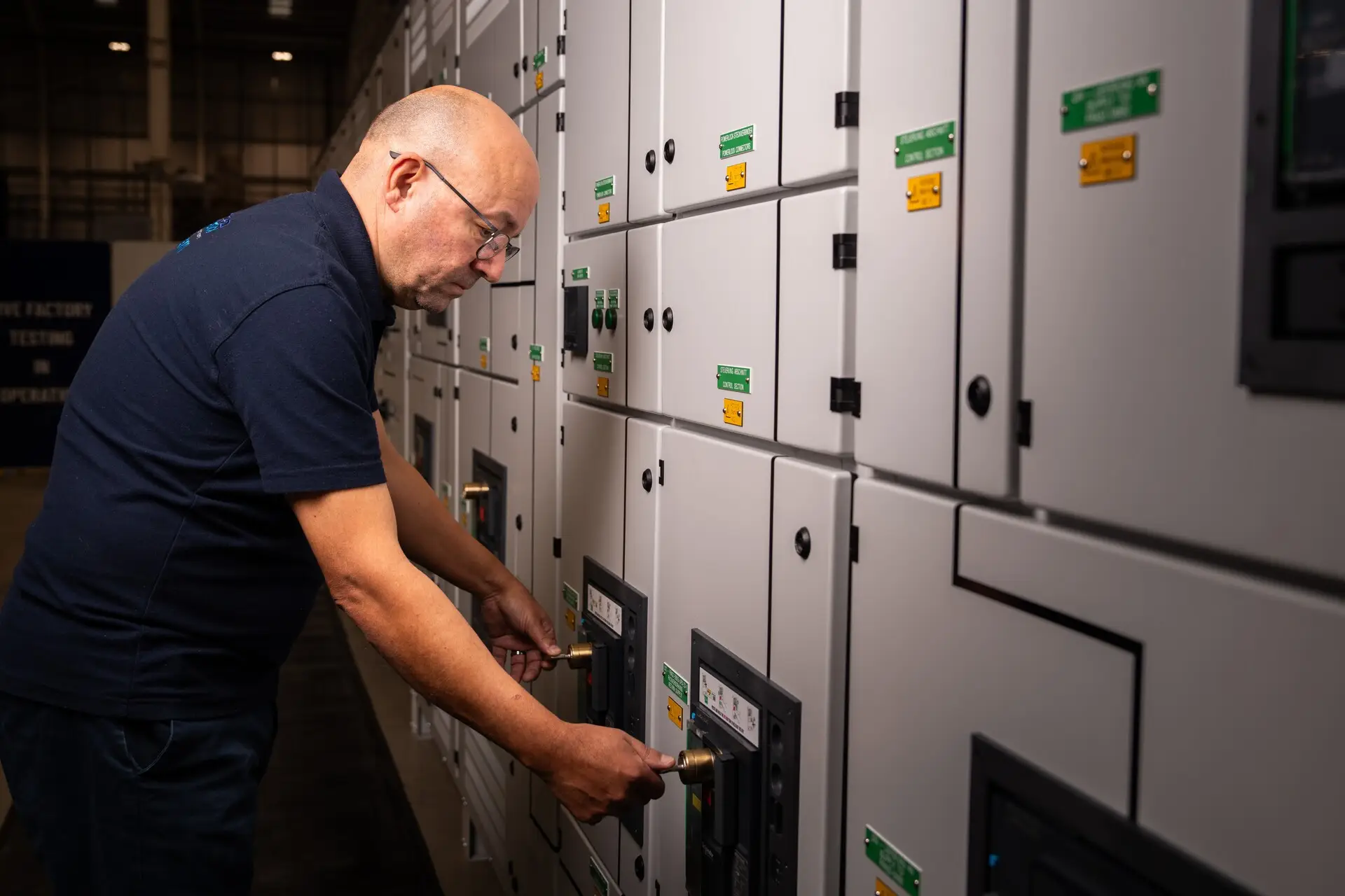 Employee using a trapped key interlock on a switchgear board