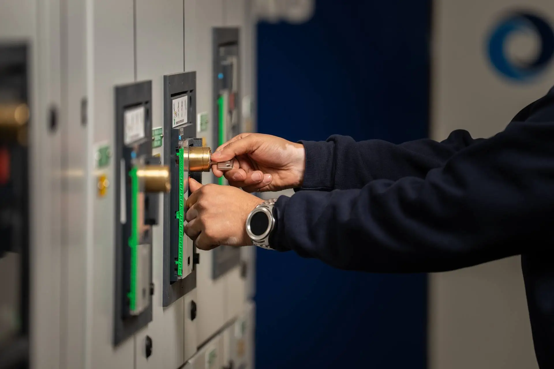 Employee hands using a trapped key interlock on a switchgear board