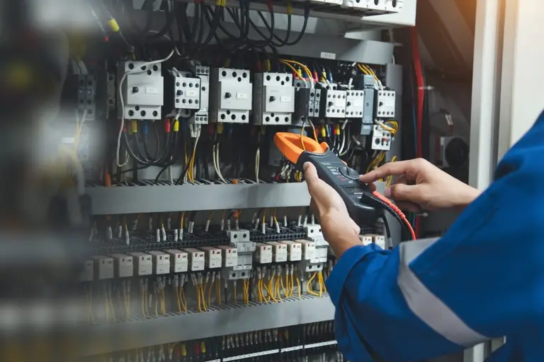 l'opérateur effectue la maintenance d'un tableau électrique dans le domaine de l'énergie.