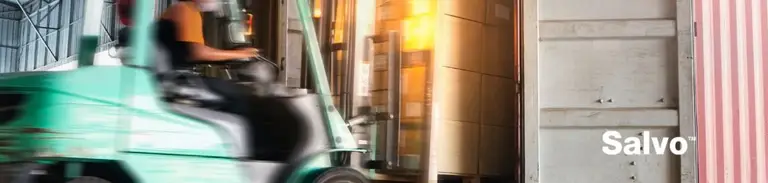 A forklift driver loads and unloads a pallet from a truck at the loading dock.